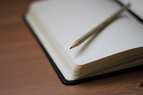 'A pencil on top of an open notebook' by Jan Kahánek on Unsplash