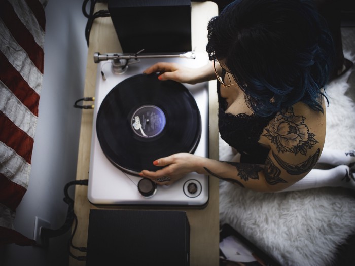 'woman holding black and gray vinyl player' by Andrew Santellan on Unsplash