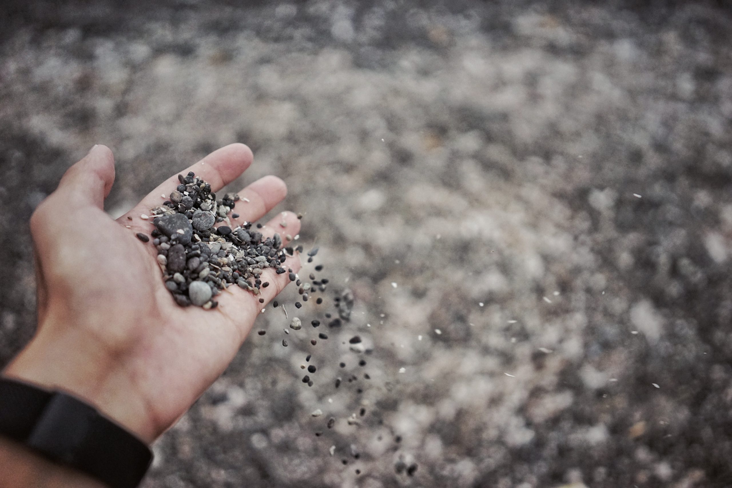 'A person wearing a watch holding a bunch of gravel in their hand' by pan xiaozhen on Unsplash